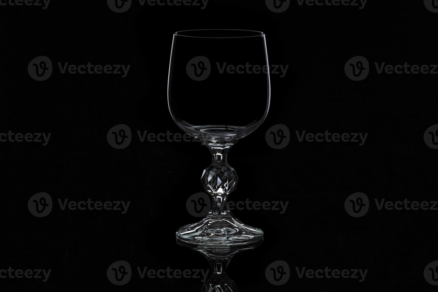 Verre à vin en verre isolé sur fond noir photo