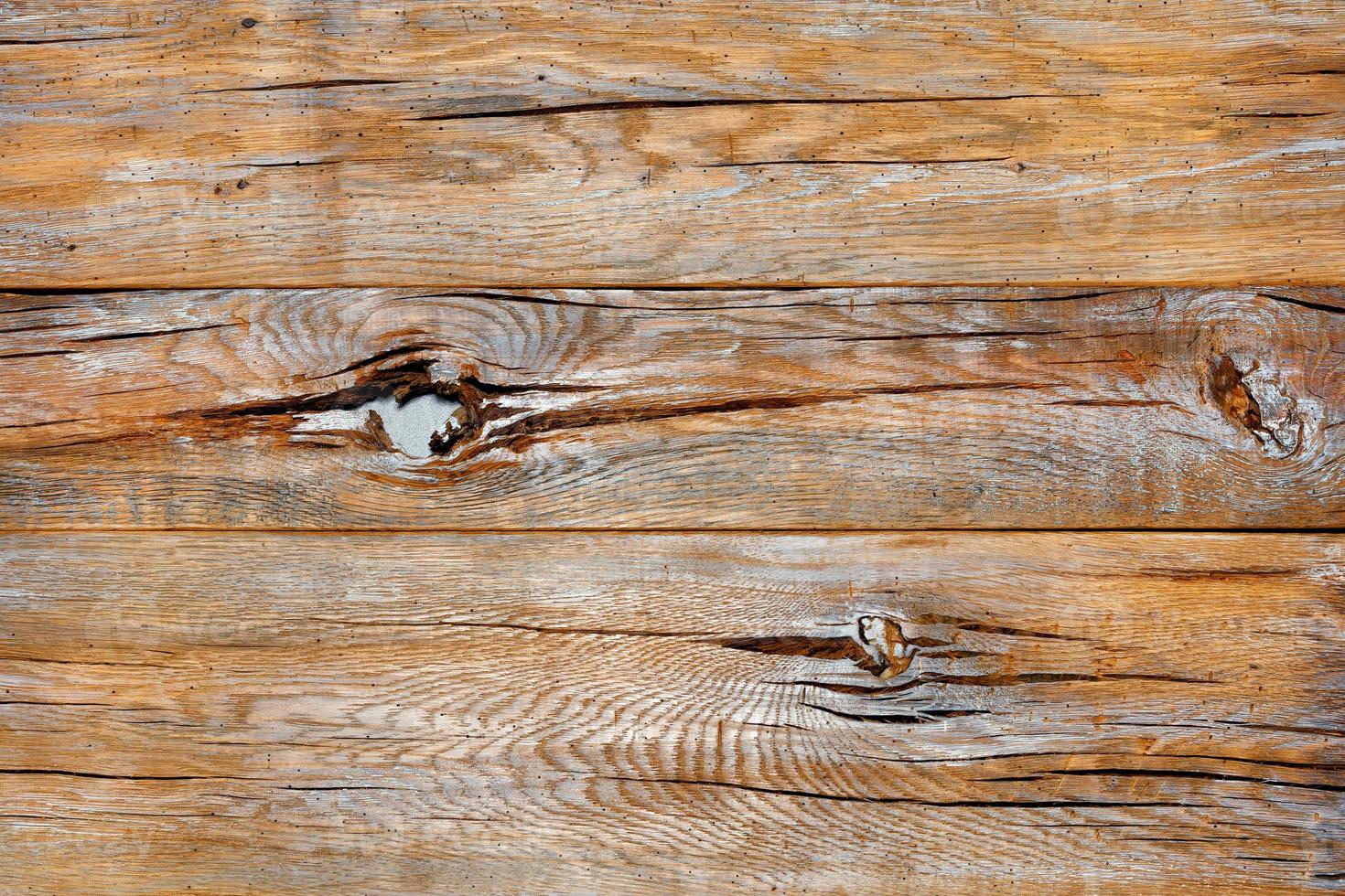 la texture d'une très vieille planche fissurée avec des taches de nœuds, des éraflures et de la peinture grise. photo