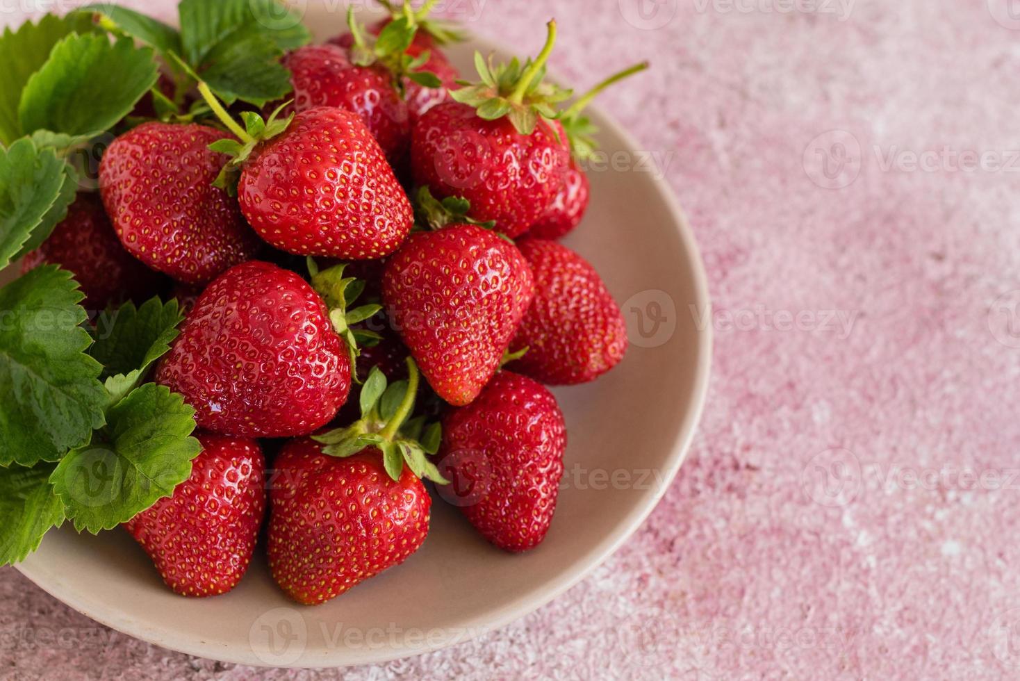 tas de fraises fraîches dans un bol en céramique photo