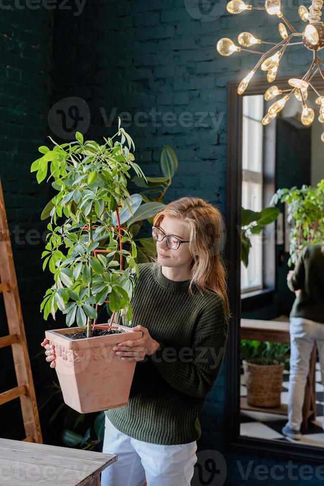 jeune femme prenant soin des plantes à la maison photo