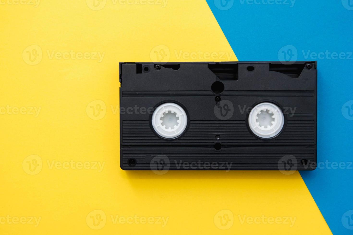 cassette de magnétoscope vhs noire sur fond jaune. ancienne technologie  obsolète pour l'enregistrement sur bande