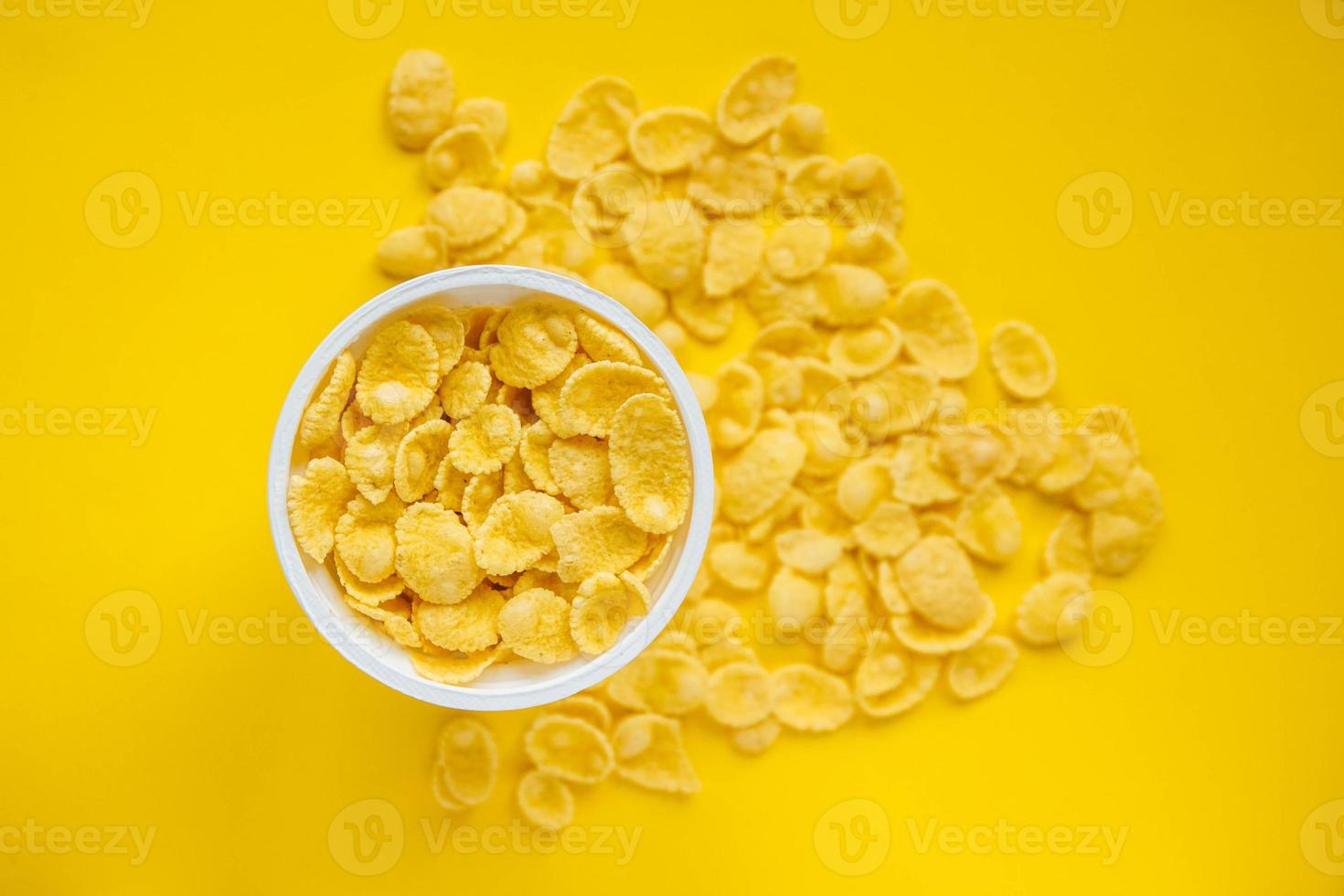 cornflakes dans un bol blanc sur fond jaune photo