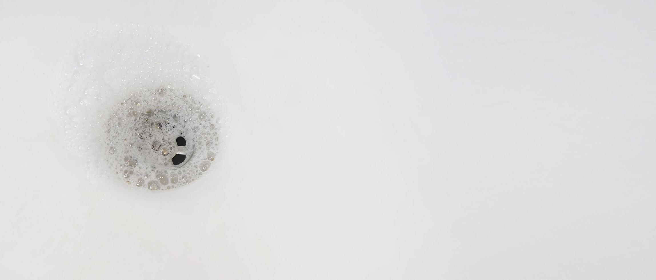 gros plan sur le drain de l'évier à gauche avec espace de copie à droite. fond de bouchon de salle de bain. concept d'hygiène, de service, de plomberie et de nettoyage. photo