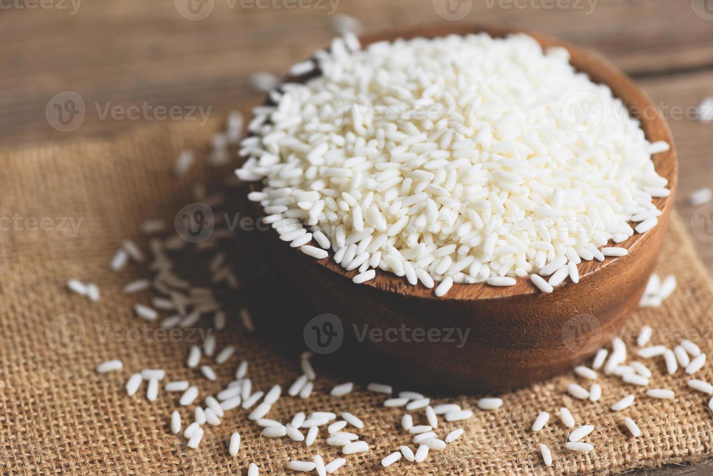 riz blanc au jasmin dans un bol en bois et riz récolté sur un sac, concept de cuisson du riz et des céréales alimentaires photo