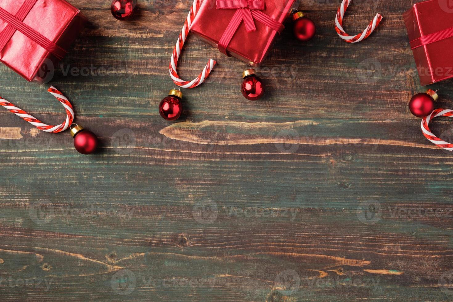 Boule de Noël rouge, boîte-cadeau, décoration de canne en bonbon sur fond de bois de table photo