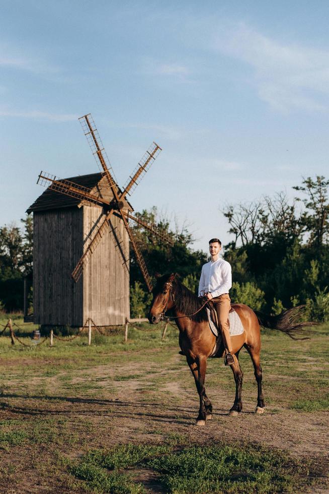 gars en chemise blanche sur une promenade avec des chevaux bruns photo