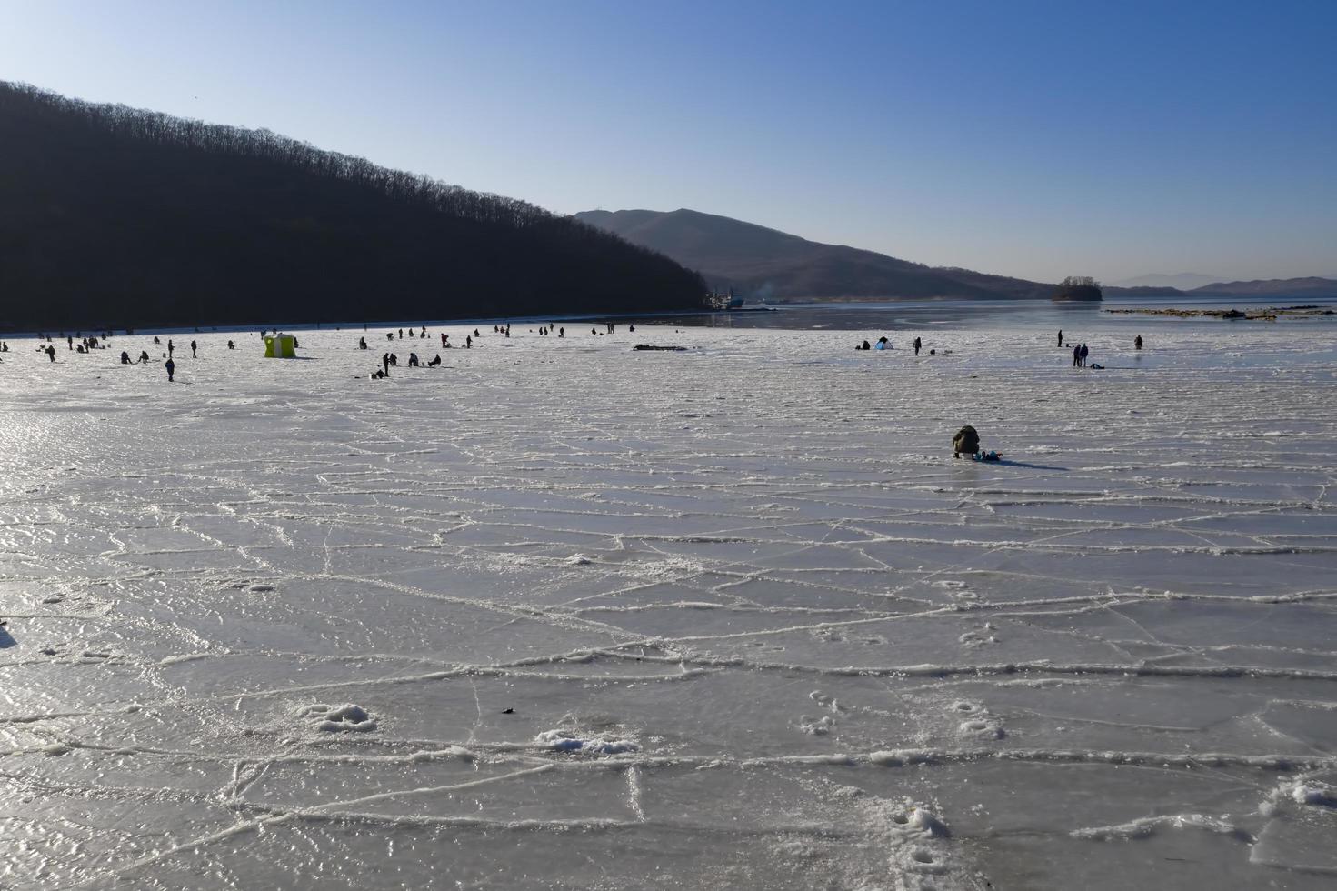 vue aérienne de la baie dans la glace avec des pêcheurs sur la pêche d'hiver. photo