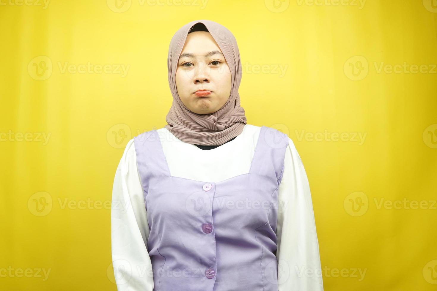 belle jeune femme musulmane asiatique faisant la moue regardant la caméra isolée sur fond jaune photo