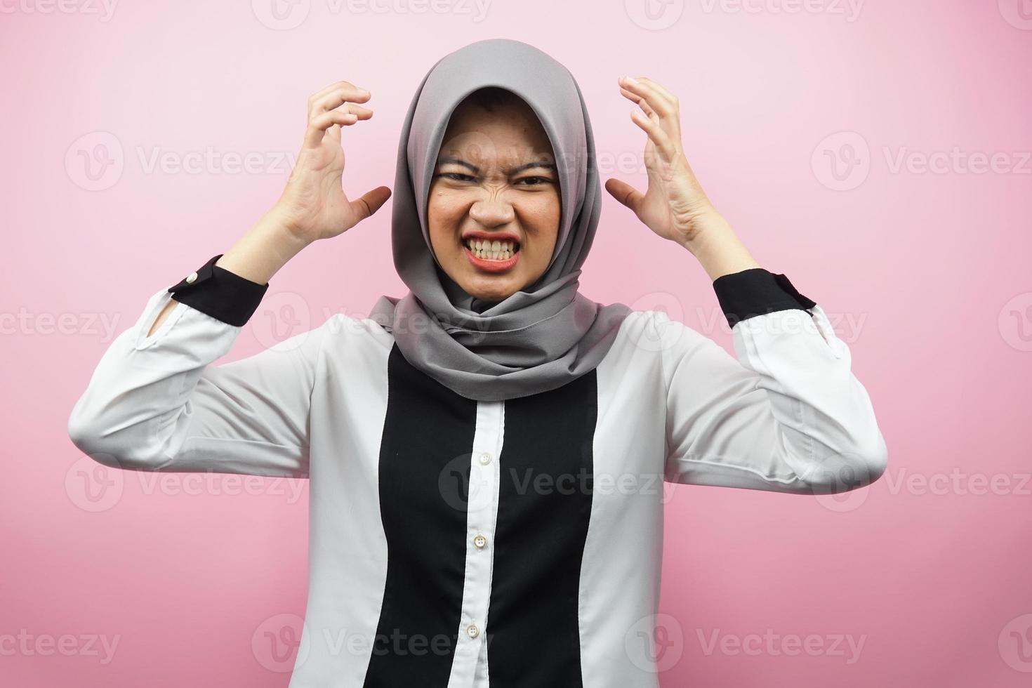belle jeune femme musulmane asiatique choquée, étourdie, stressée, malheureuse, beaucoup de problèmes, veut une solution, avec les mains sur la tête isolée sur fond rose photo