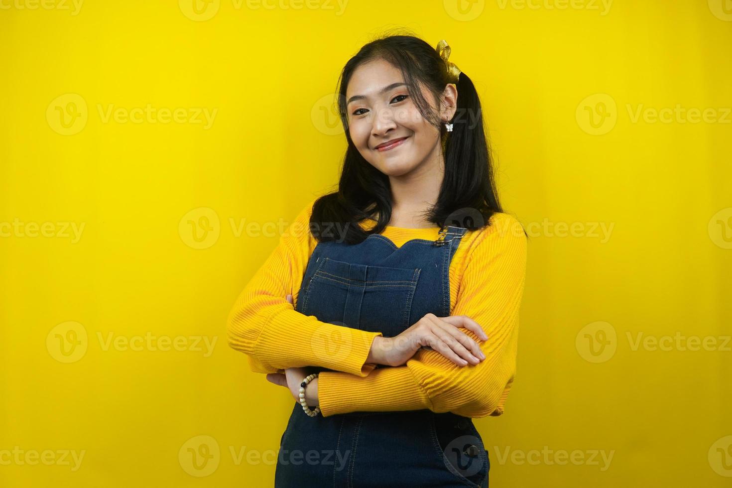 jolie et mignonne jeune femme joyeuse, souriante avec confiance les bras croisés, isolée photo