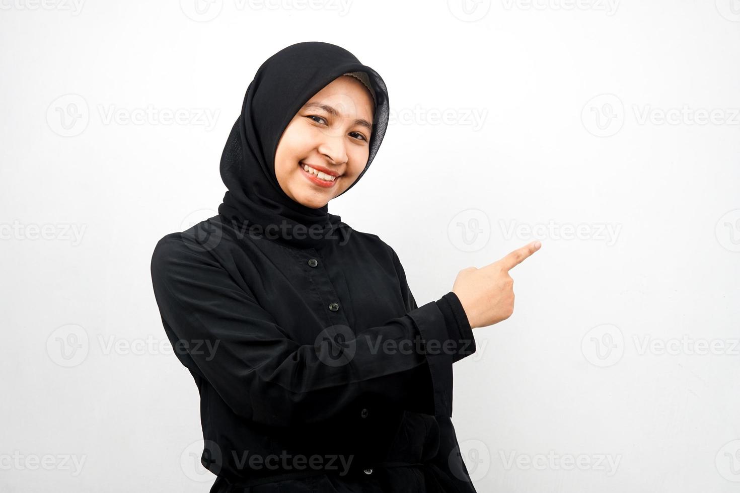 belle jeune femme musulmane asiatique avec les mains pointant l'espace vide présentant quelque chose, souriant confiant, enthousiaste, joyeux, regardant la caméra, isolé sur fond blanc, concept publicitaire photo