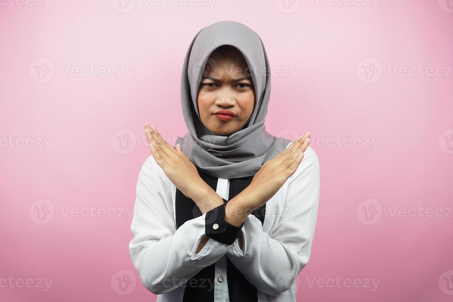 belle jeune femme musulmane asiatique aux bras croisés, mains montrant le refus, mains montrant l'interdiction, mains montrant la désapprobation, isolées sur fond rose photo