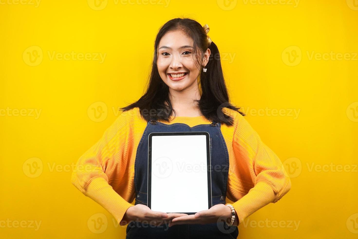 jolie et mignonne jeune femme joyeuse, confiante, avec les mains tenant une tablette, avec une tablette à écran blanc ou blanc, présentant quelque chose, faisant la promotion du produit, de la publicité, isolée photo