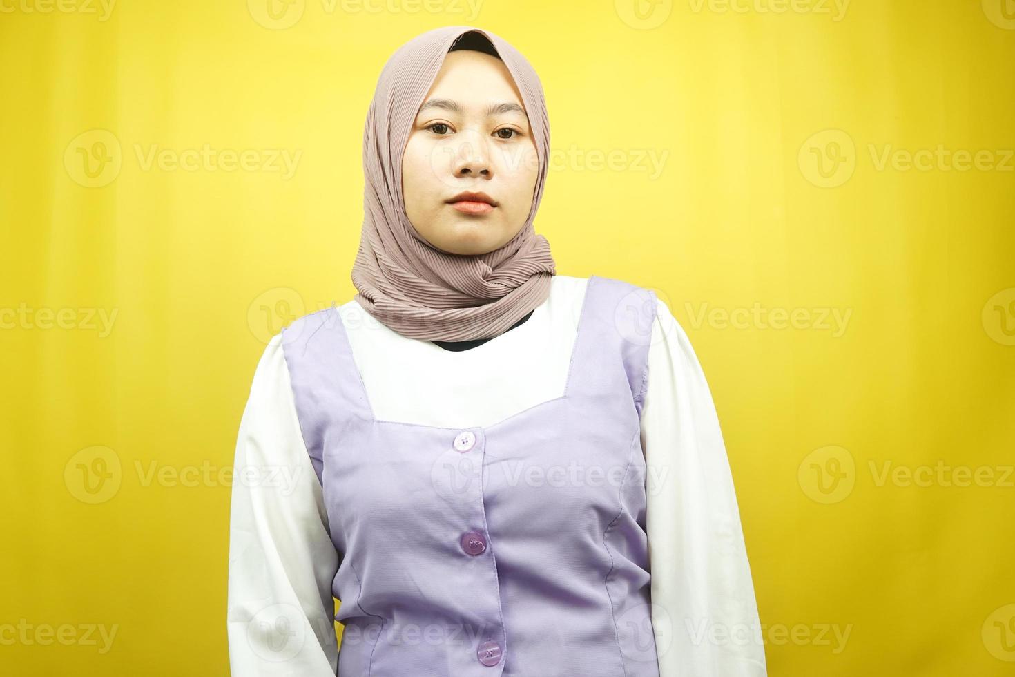 belle jeune femme musulmane asiatique faisant la moue regardant la caméra isolée sur fond jaune photo