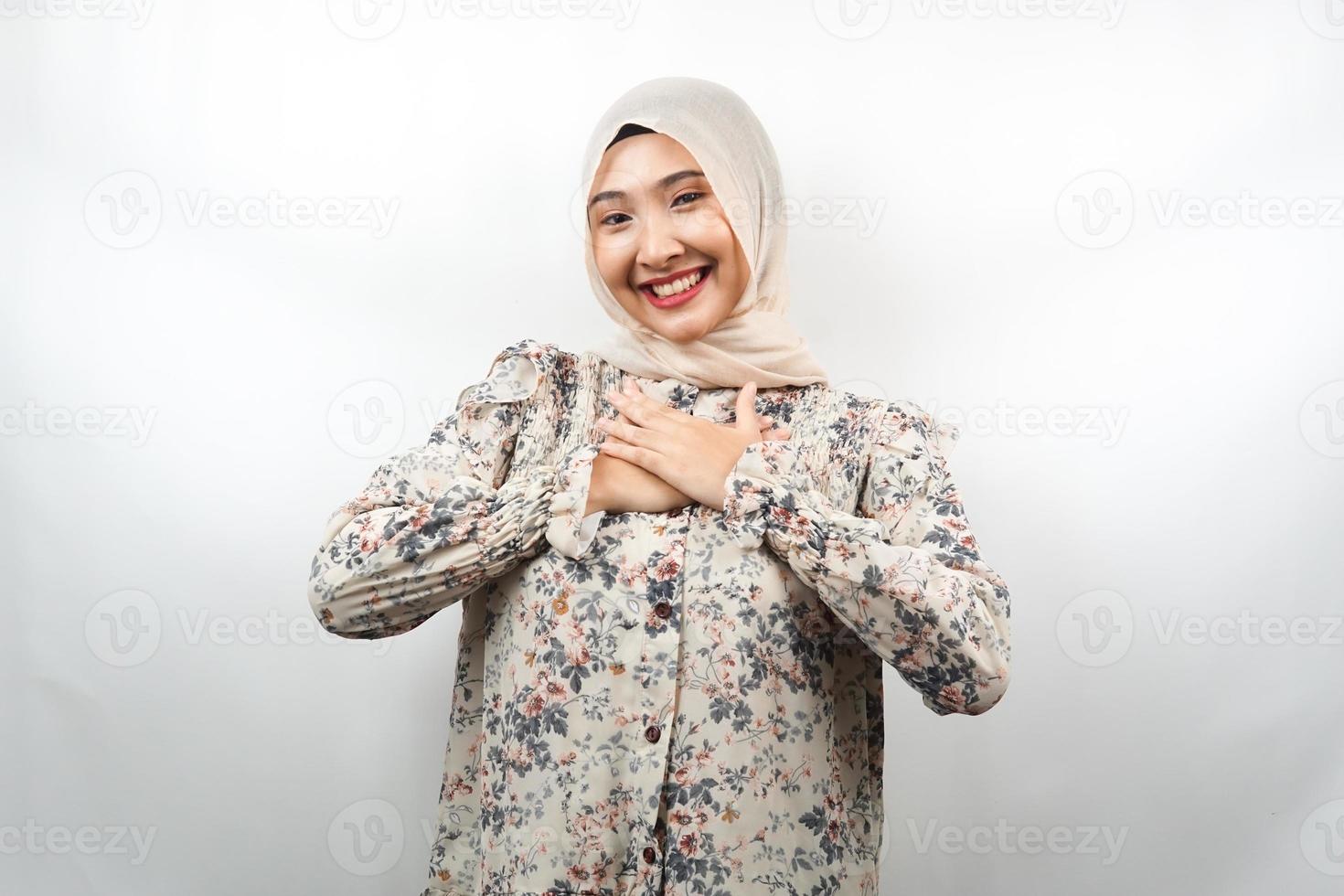 belle jeune femme musulmane asiatique souriante surprise et joyeuse, les mains tenant la poitrine, excitée, ne s'attendant pas, regardant la caméra isolée sur fond blanc photo