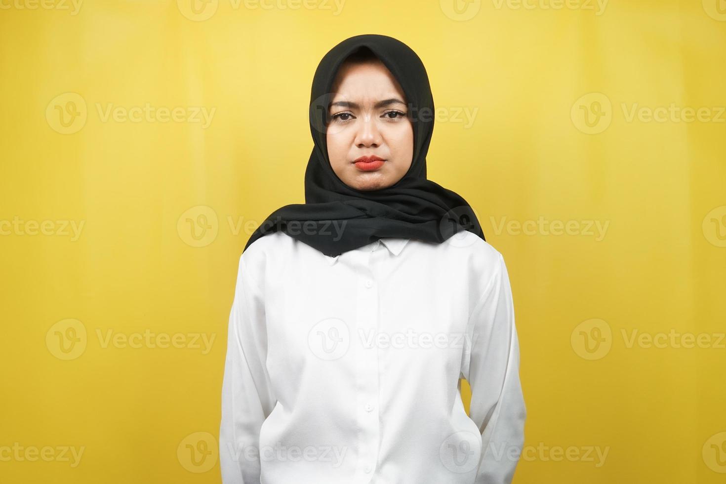 belle jeune femme musulmane asiatique faisant la moue regardant la caméra isolée sur fond jaune photo