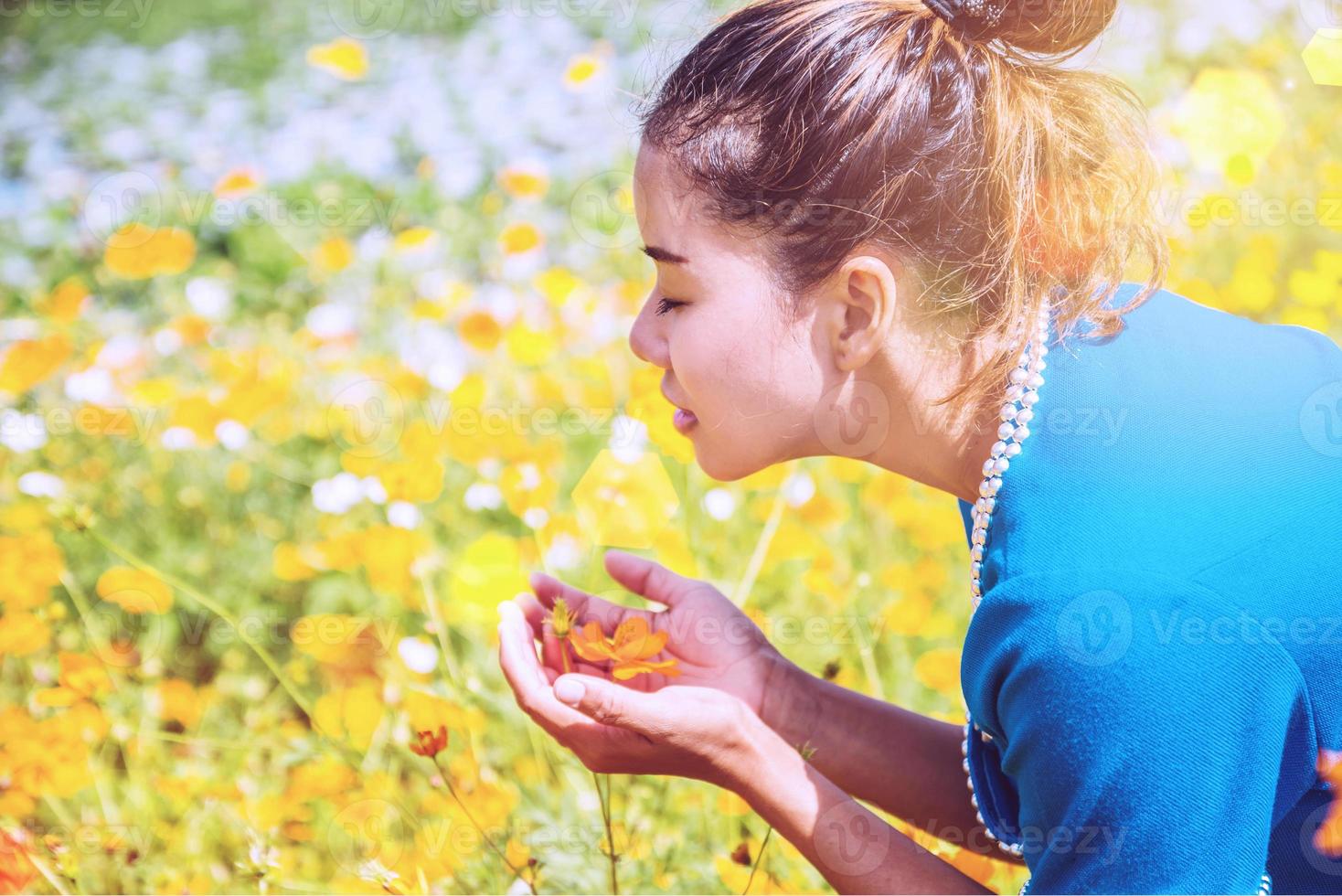 les femmes asiatiques voyagent dormir se détendre. tribu des femmes des collines dans le domaine des fleurs cosmos sulphureus. Thaïlande photo