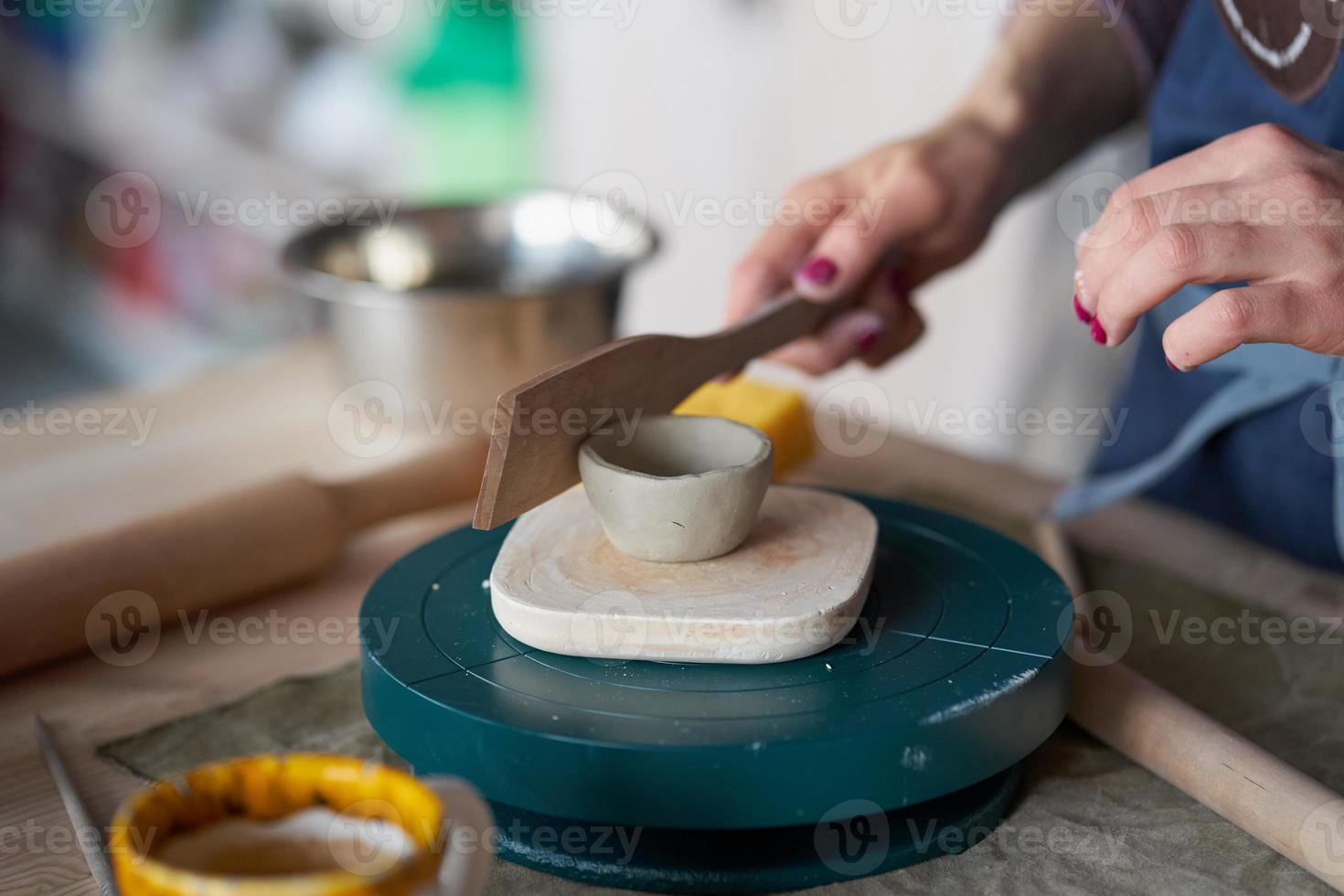 femme faisant de la poterie, mains en gros plan, arrière-plan flou, se concentrer sur les potiers, palmiers avec poterie photo