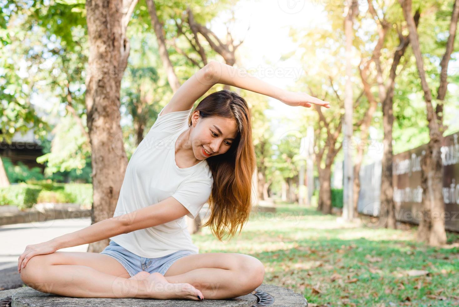 jeune femme asiatique yoga en plein air garder son calme et méditer tout en pratiquant le yoga pour explorer la paix intérieure. le yoga et la méditation ont de bons avantages pour la santé. yoga sport et concept de mode de vie sain. photo