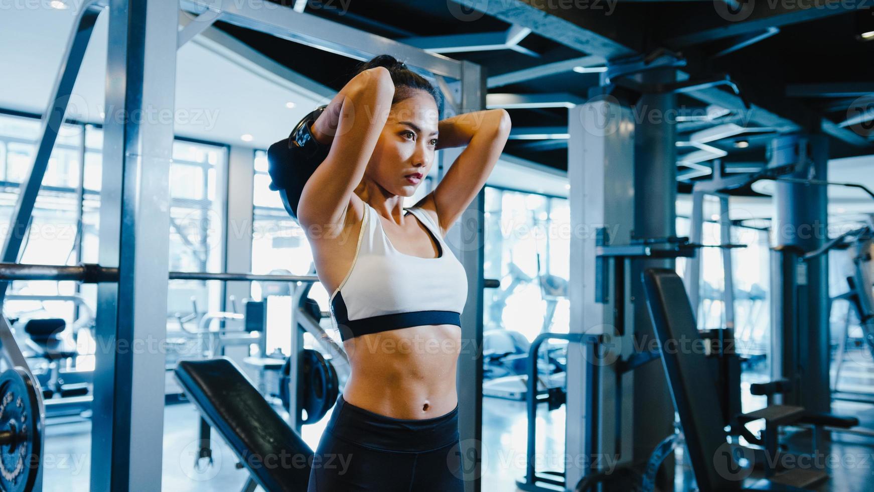 belle jeune femme d'asie faisant de l'exercice en levant des haltères pour brûler les graisses en cours de fitness. athlète avec six pack, activité récréative sportive, entraînement fonctionnel, concept de mode de vie sain. photo