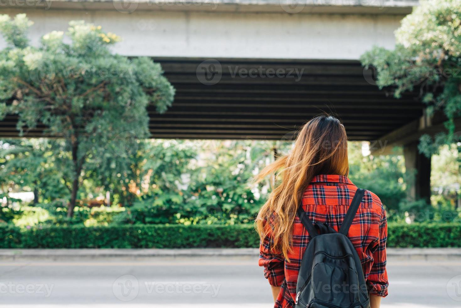 jeunes femmes asiatiques debout le long de la rue profitant de son style de vie en ville le matin d'un week-end en attente d'une activité de plein air. jeune femme et son mode de vie citadin. mode de vie urbain et concept de plein air. photo