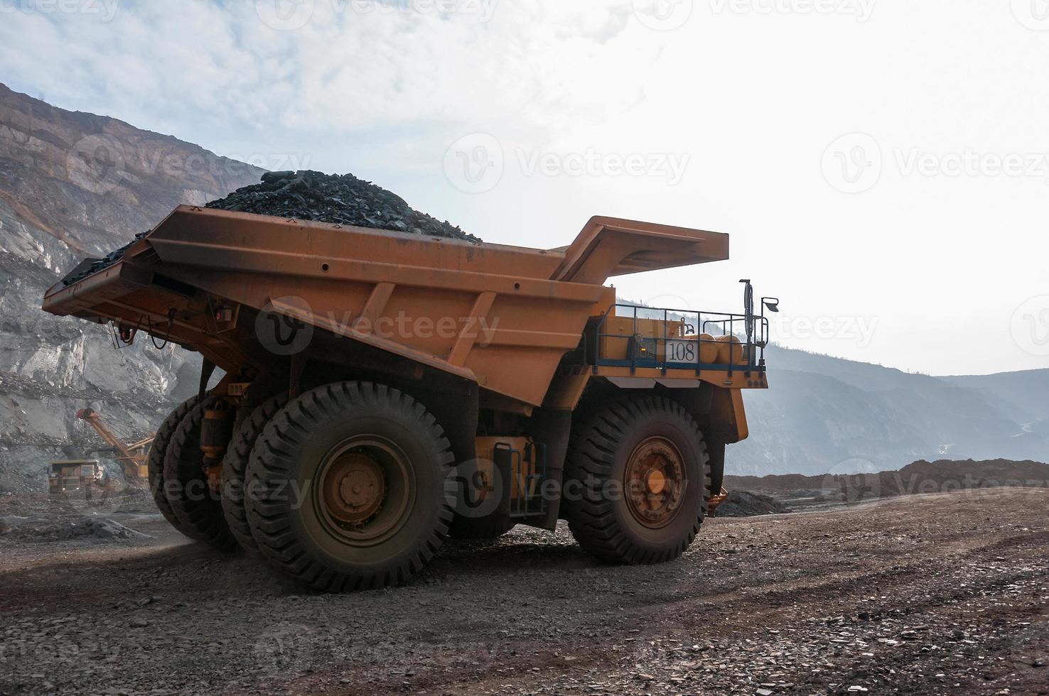 Les camions à benne basculante de la mine à ciel ouvert conduisent seuls la zone industrielle de la carrière de minerai de fer photo