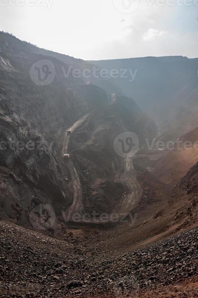 Les camions à benne basculante de la mine à ciel ouvert conduisent seuls la zone industrielle de la carrière de minerai de fer photo