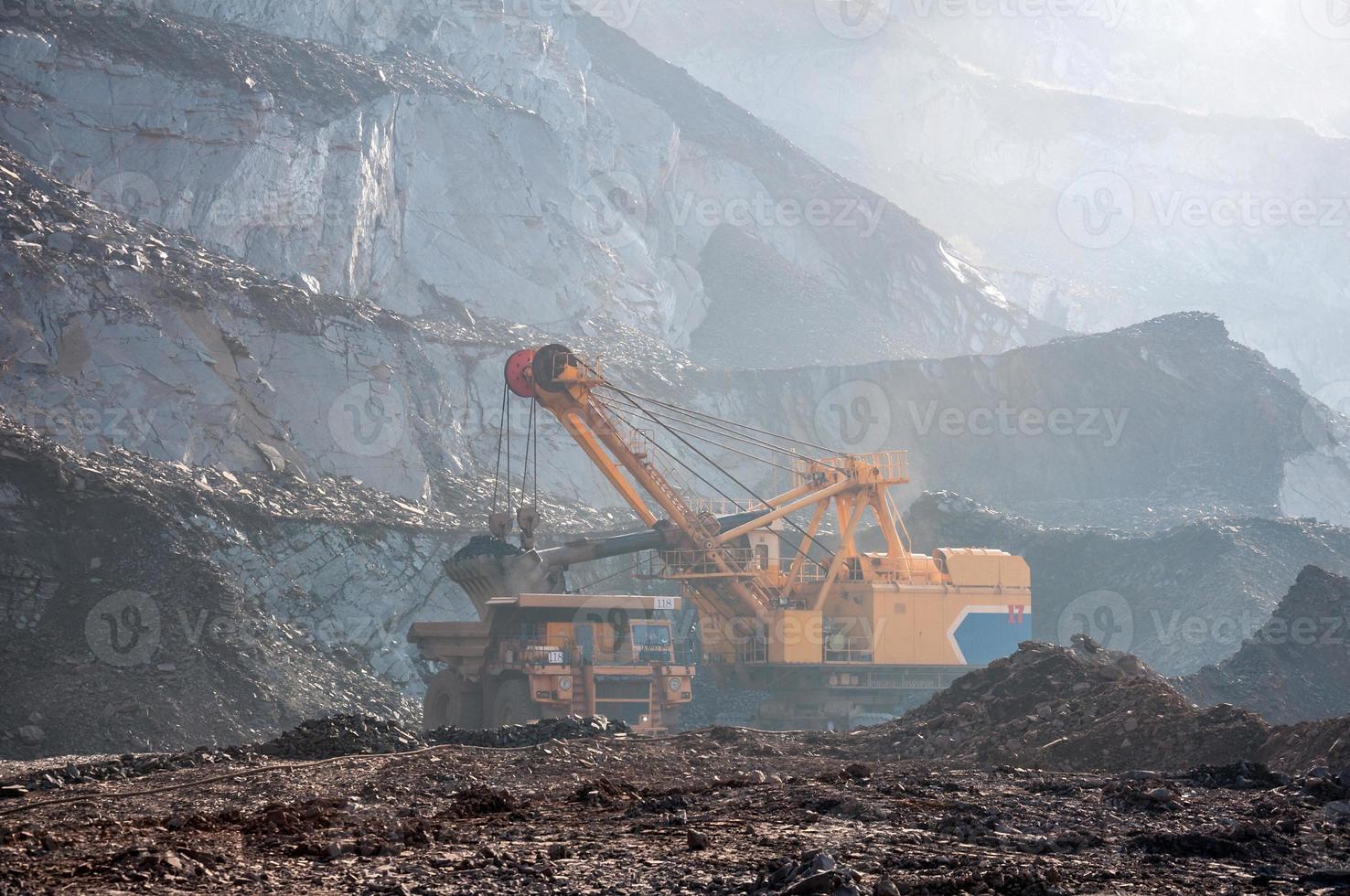 Les camions à benne basculante de la mine à ciel ouvert conduisent seuls la zone industrielle de la carrière de minerai de fer photo