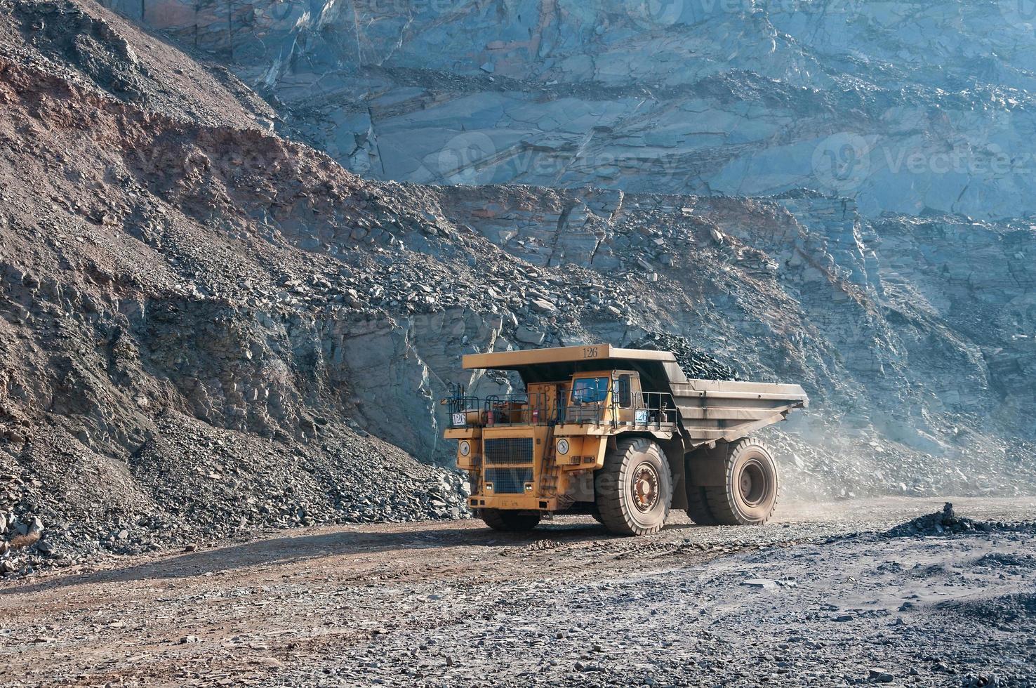 Les camions à benne basculante de la mine à ciel ouvert conduisent seuls la zone industrielle de la carrière de minerai de fer photo