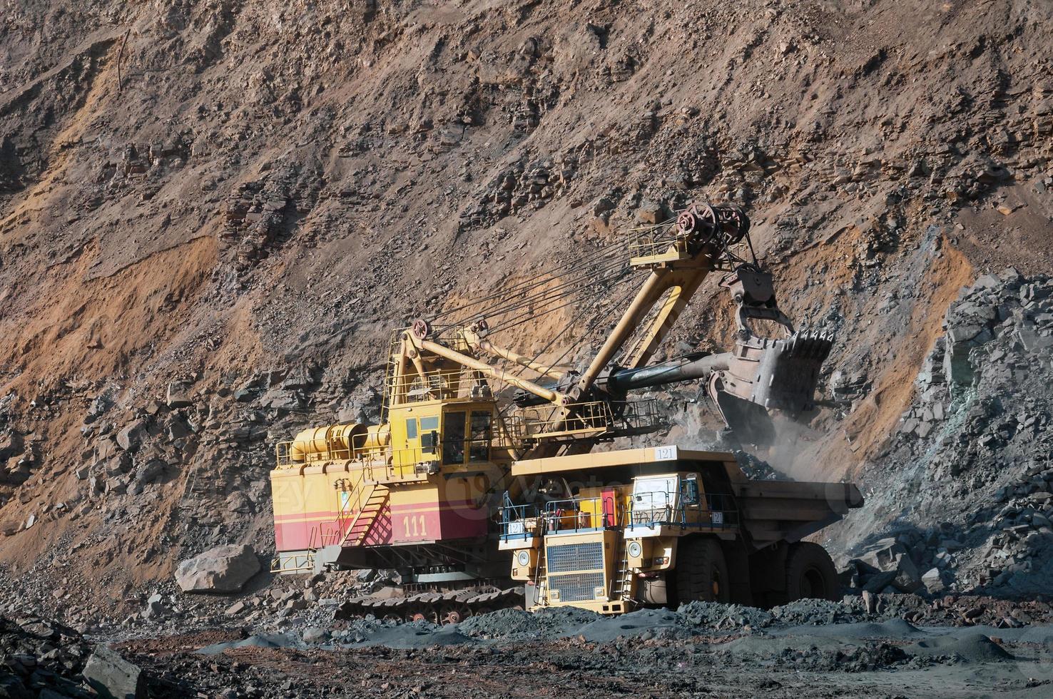 Les camions à benne basculante de la mine à ciel ouvert conduisent seuls la zone industrielle de la carrière de minerai de fer photo