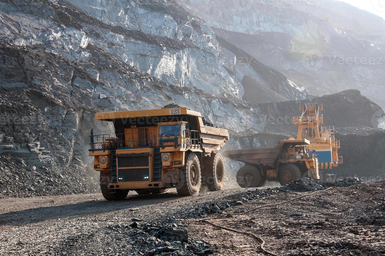 Les camions à benne basculante de la mine à ciel ouvert conduisent seuls la zone industrielle de la carrière de minerai de fer photo