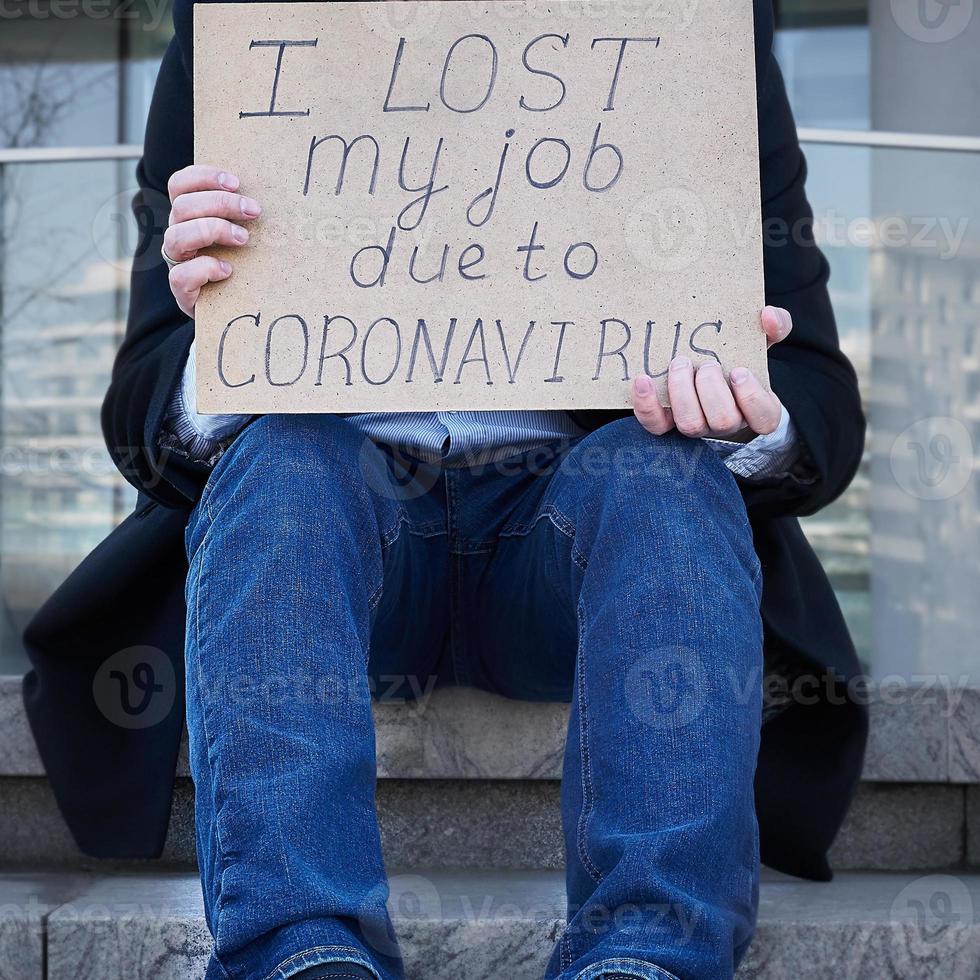perte d'emploi due au concept de pandémie du virus covid-19. un homme méconnaissable tient une pancarte j'ai perdu mon travail photo