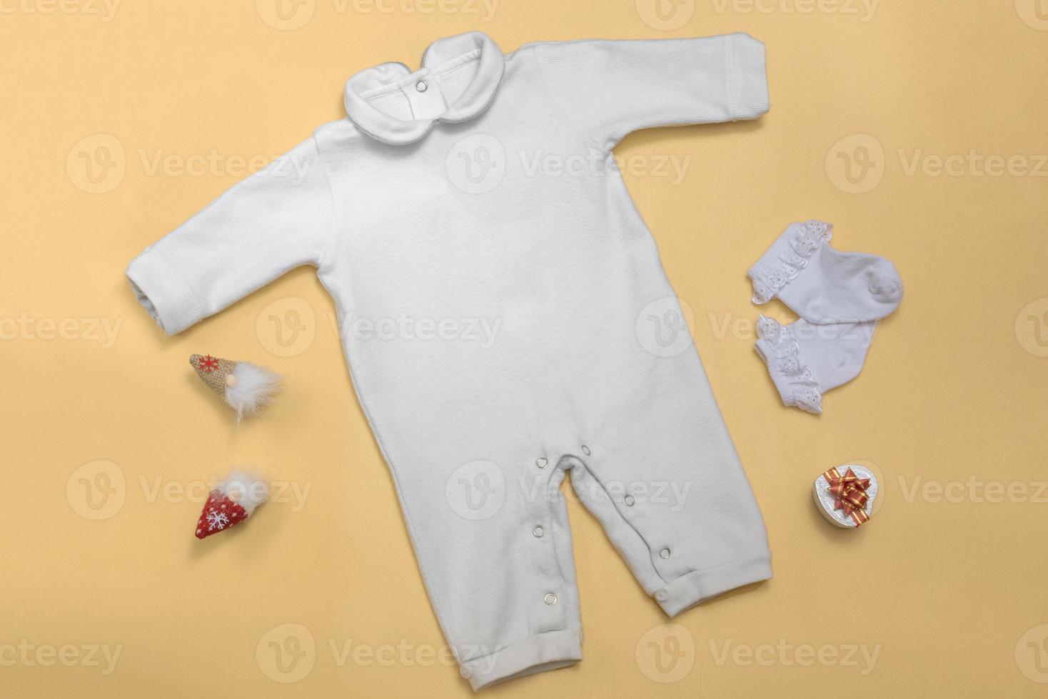 maquette d'un body de bébé blanc sur un fond coloré en gros plan avec un pantalon rouge et une maquette de gnomes de vêtements pour nouveau-nés. avec espace copie photo