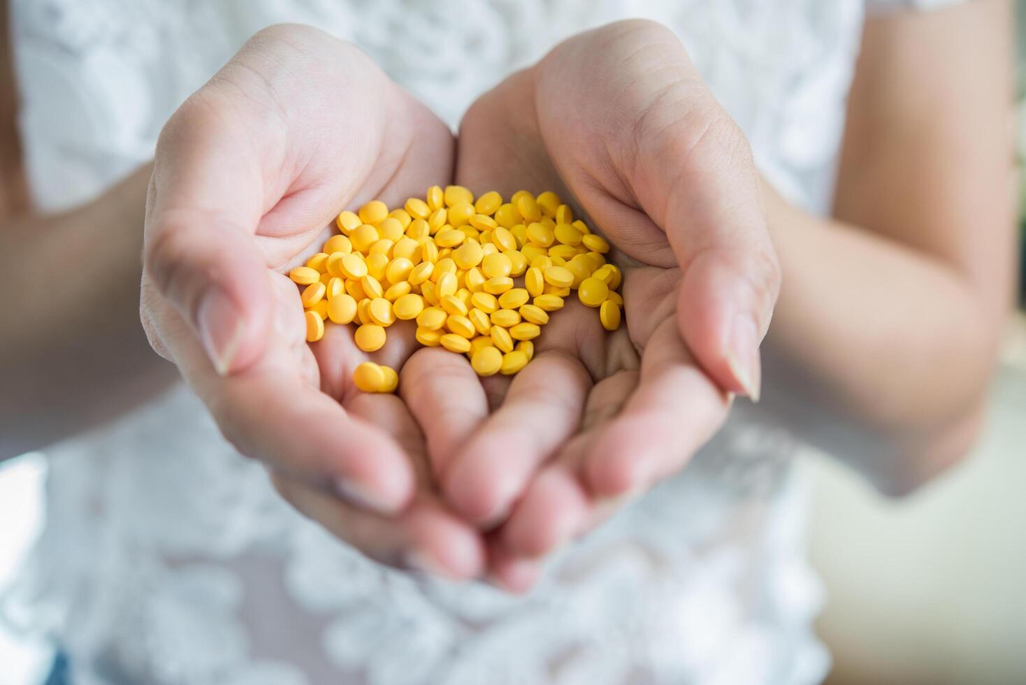 la main de la femme verse les pilules de médecine hors de la bouteille photo