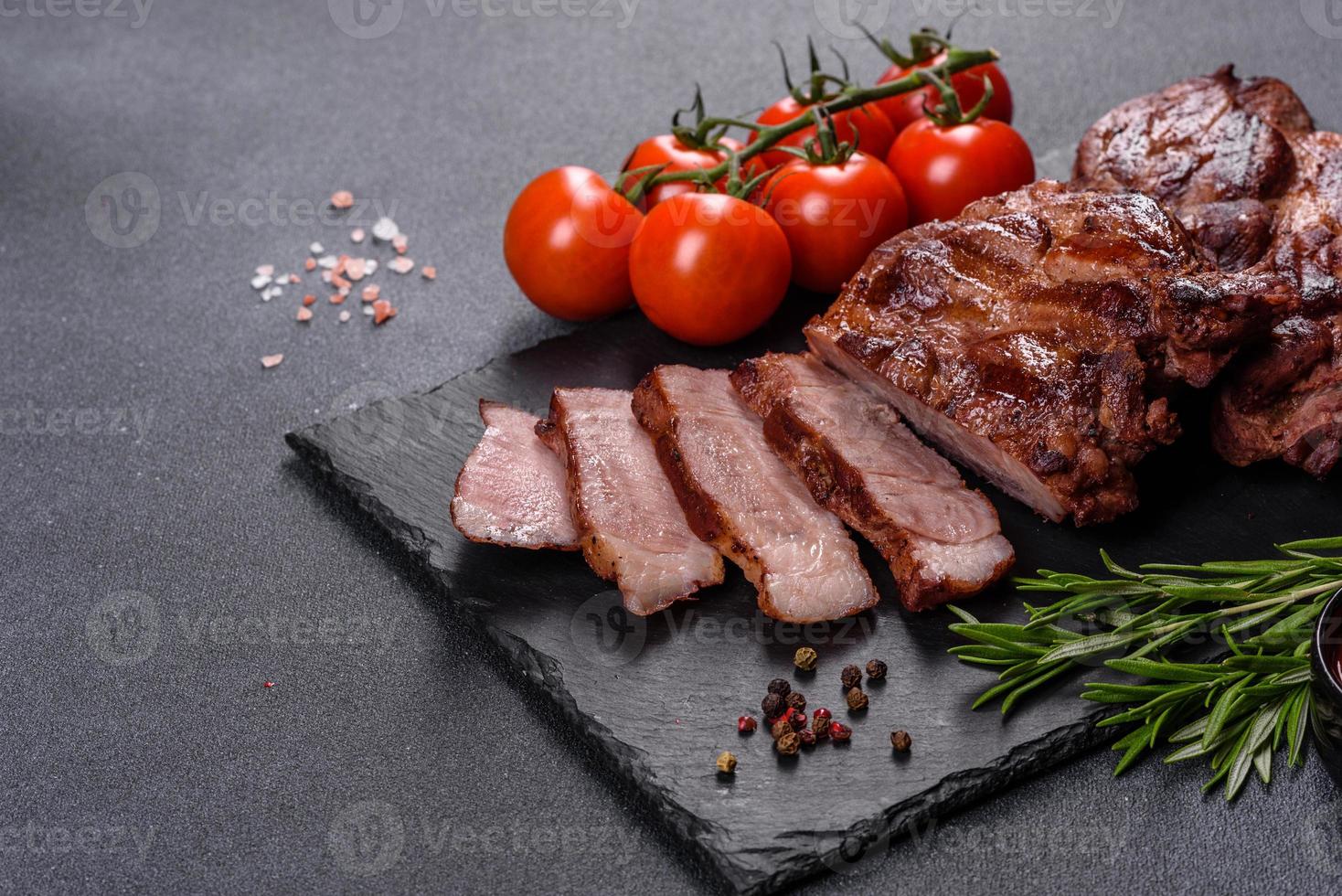steaks de boeuf grillés aux épices sur une planche à découper sombre photo