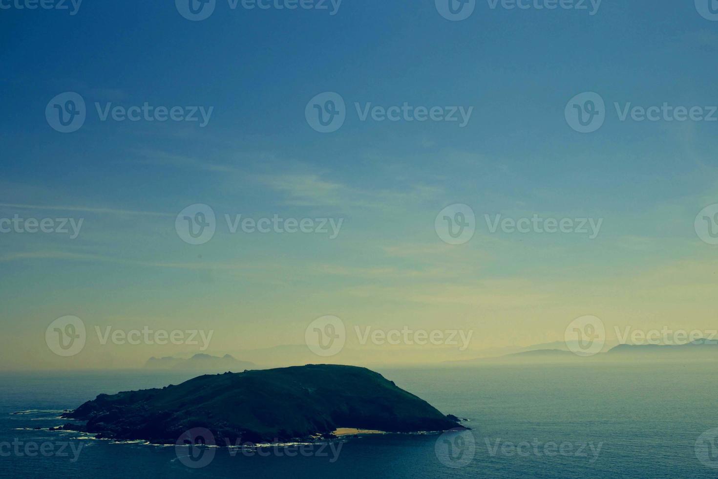 vert et bleu de la mer et bleu ciel belle mer et coucher de soleil avec un grand soleil jaune sous les collines de la surface de la mer en arrière-plan. photo