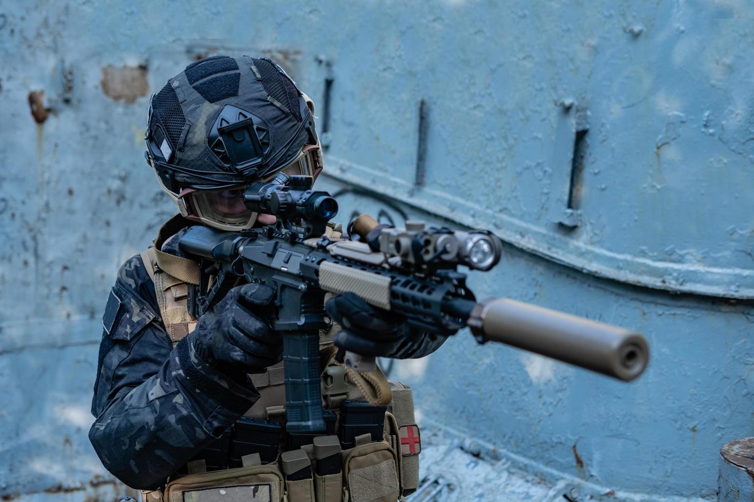soldat moderne en uniforme noir multicam avec fusil, fond urbain photo