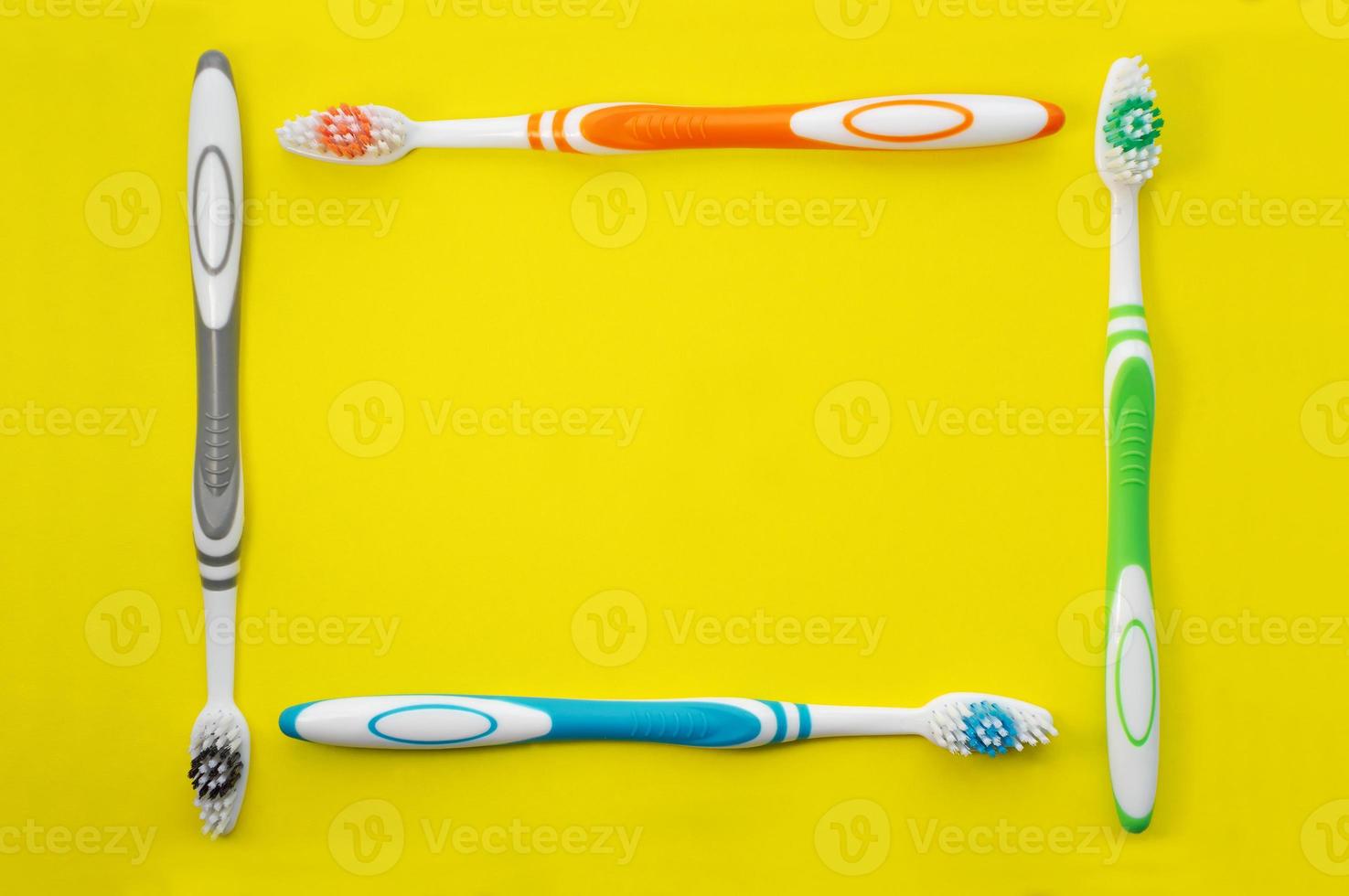 brosses à dents multicolores sur fond jaune. la vue d'en haut. fermer. photo
