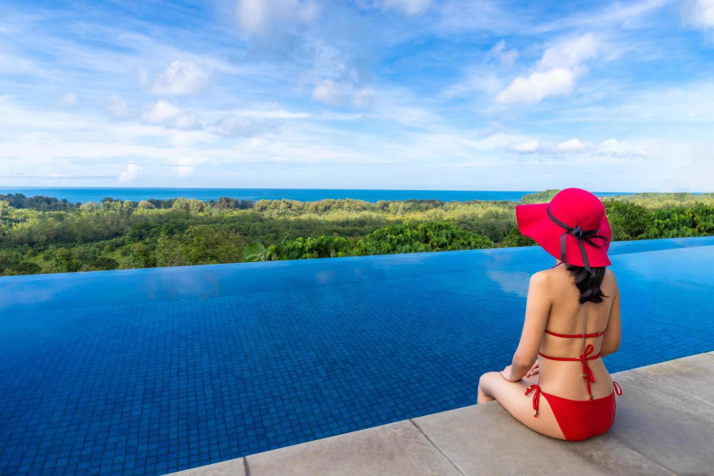 Jeune femme asiatique en bikini avec chapeau assis au bord de la piscine plage vacances d'été phuket thaïlande photo
