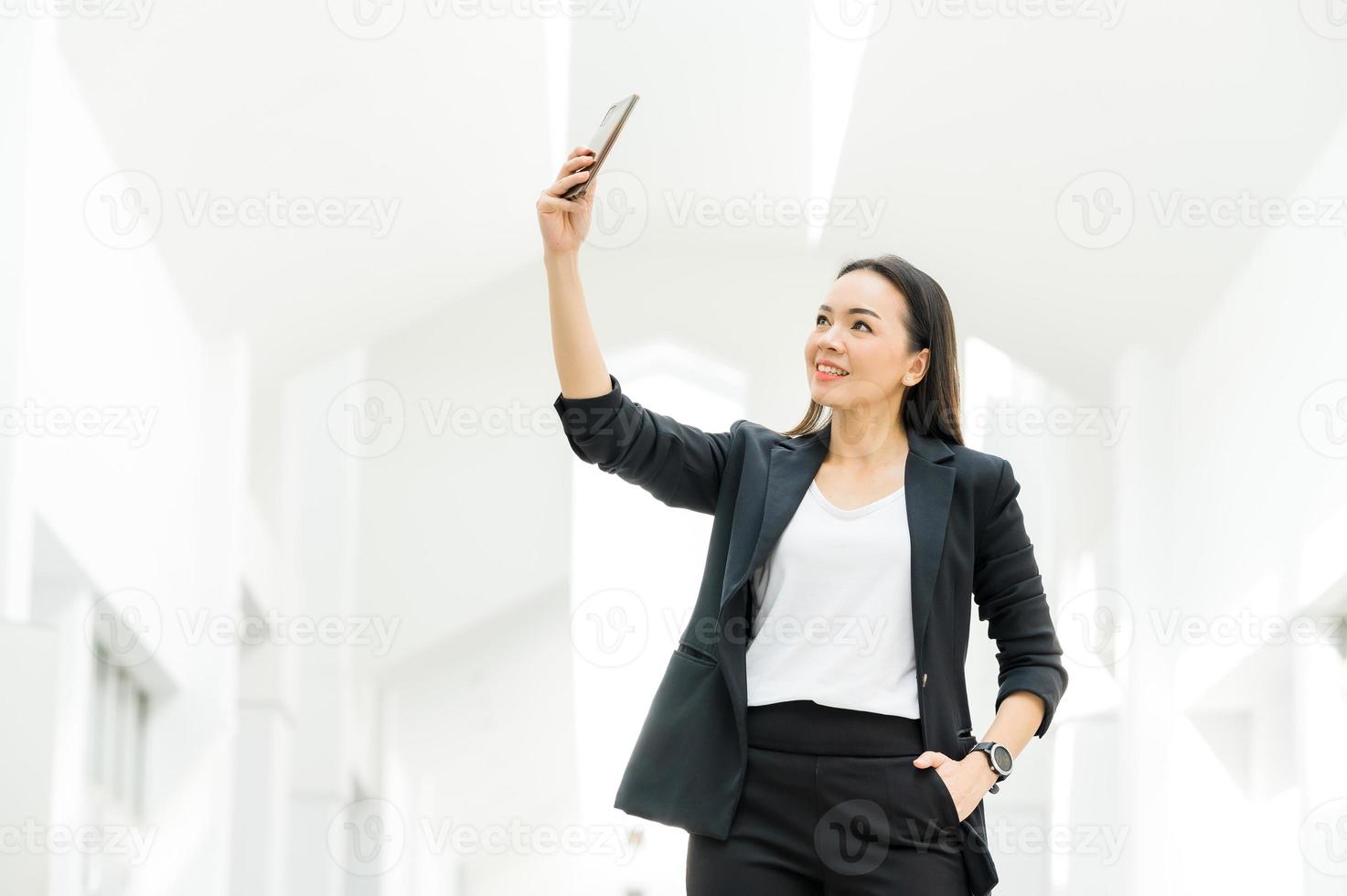 femme au travail asiatique tenant un téléphone portable debout au bureau concept de femme d'affaires femme d'affaires dans la technologie de la classe photo