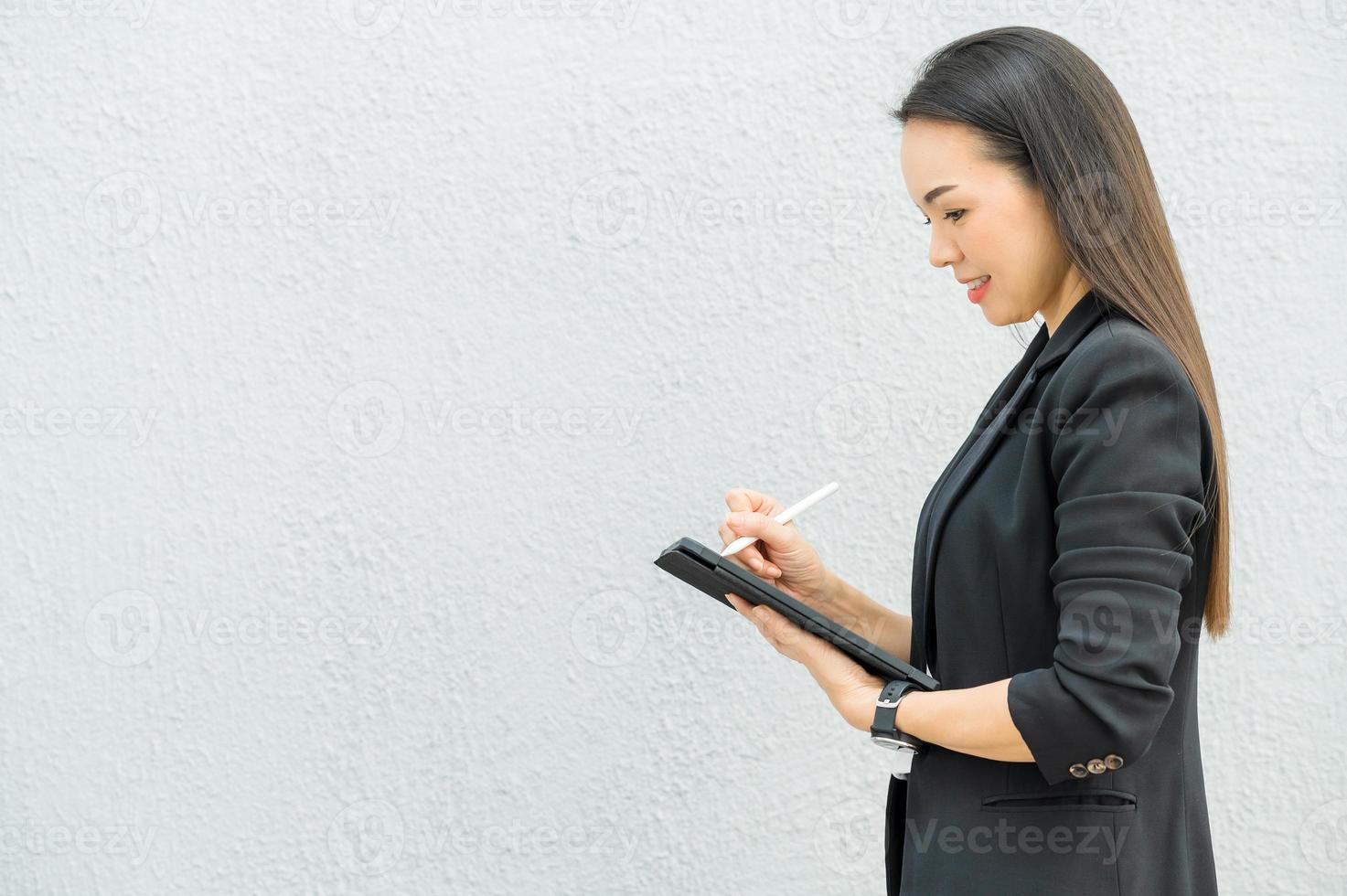 femme de travail asiatique tenant une tablette au bureau femme de travail concept femme d'affaires avec la technologie photo