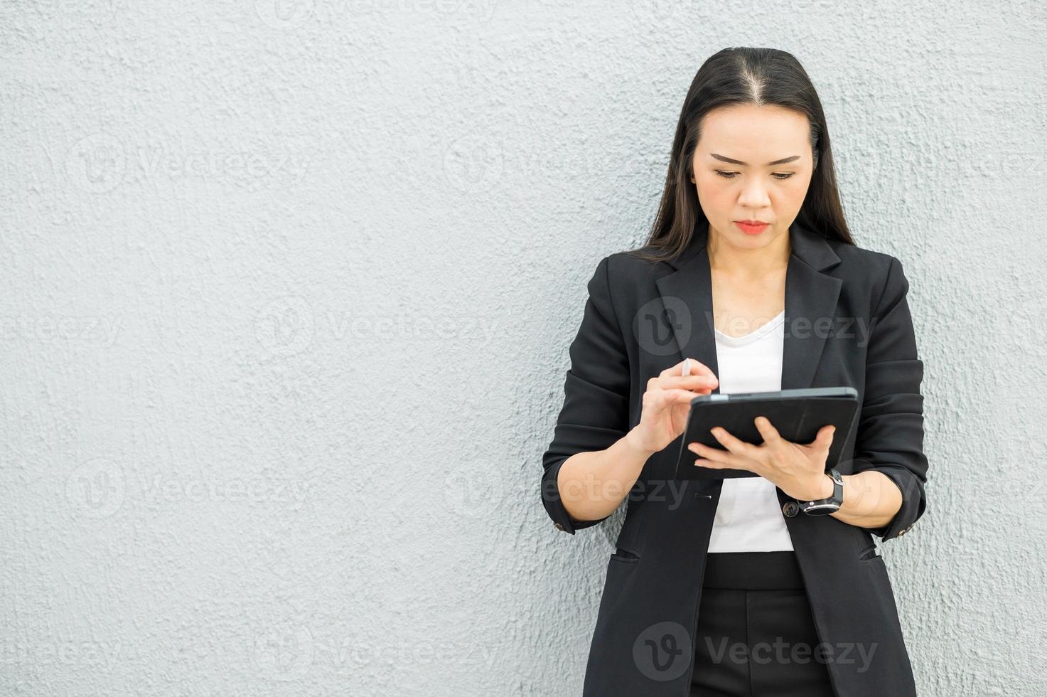 femme de travail asiatique tenant une tablette au bureau femme de travail concept femme d'affaires avec la technologie photo