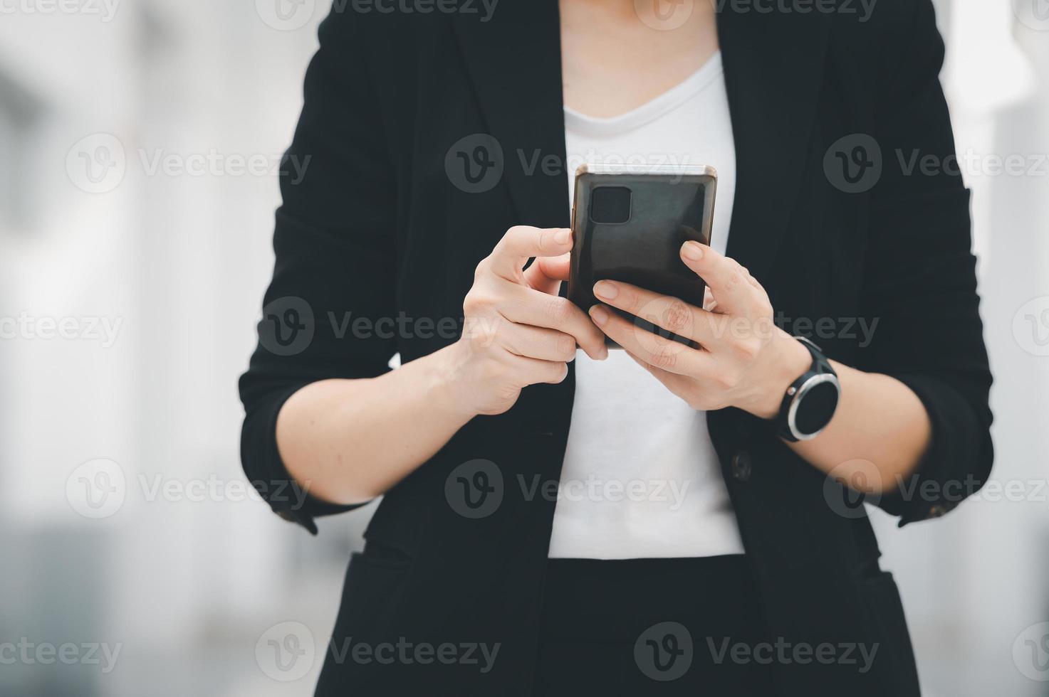 femme au travail asiatique tenant un téléphone portable debout au bureau concept de femme d'affaires femme d'affaires dans la technologie de la classe photo