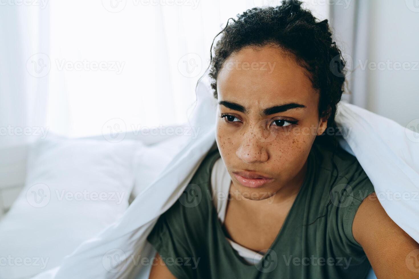 femme afro-américaine mécontente s'est enveloppée dans une couverture et regardant sur le côté photo