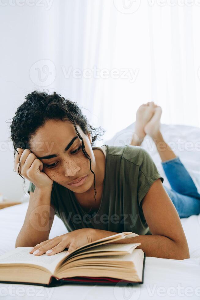 Portrait d'un livre de lecture de femme africaine concentrée photo