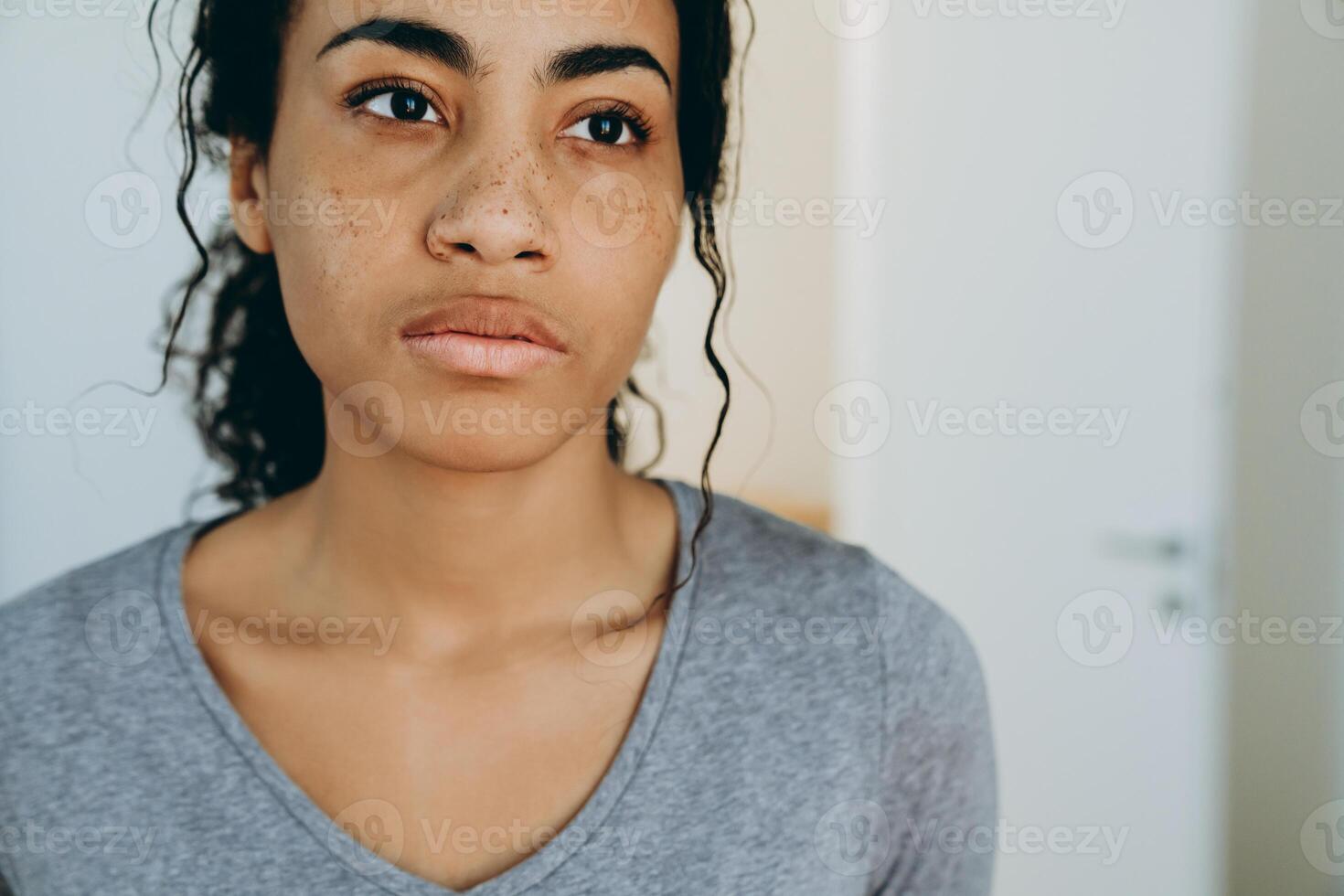 Jeune femme noire regardant de côté pendant qu'elle passe du temps à la maison photo