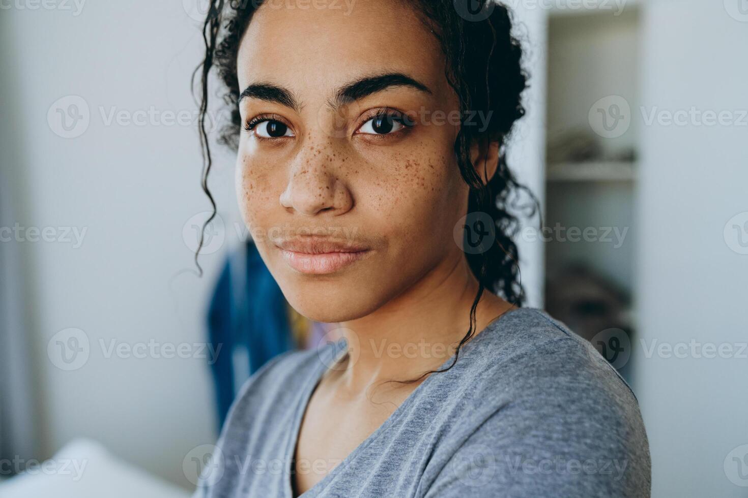 femme noire regardant la caméra pendant qu'elle passe du temps à la maison photo