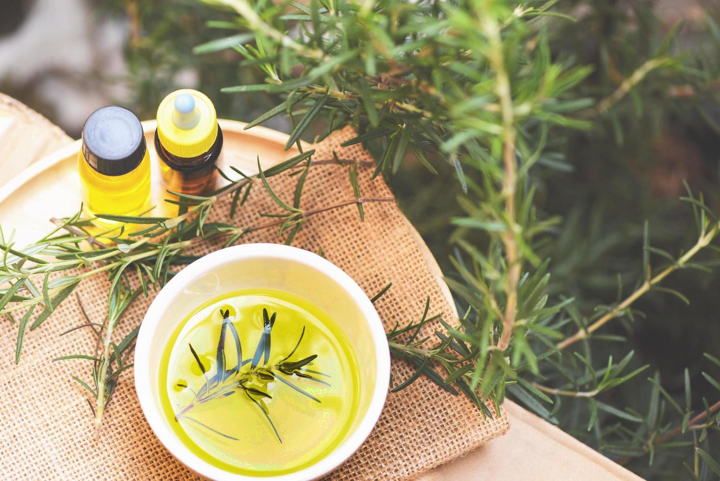 bouteille d'huile essentielle ingrédients naturels du spa huile de romarin pour l'aromathérapie et plante à feuilles de romarin sur fond - cosmétiques biologiques aux extraits d'herbes photo