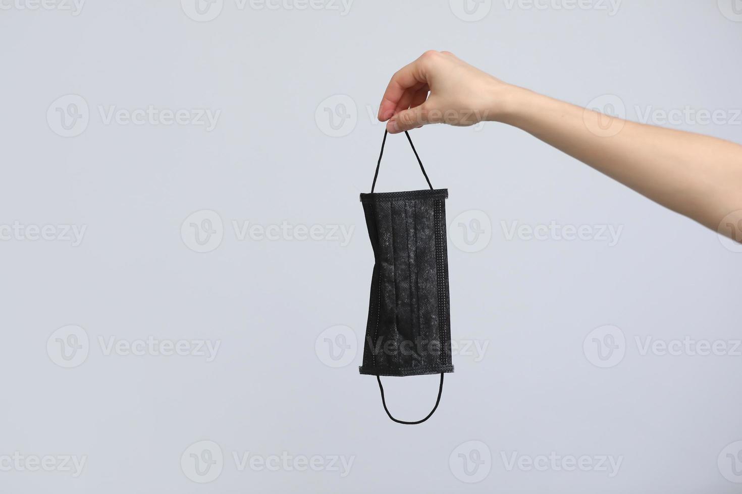 masque médical. les mains des femmes tiennent un masque pour la protection covid-19 isolé sur fond. pendant une épidémie et une quarantaine, les gens portent des masques antibactériens. hôpital, laboratoire, clinique. noir et blanc photo