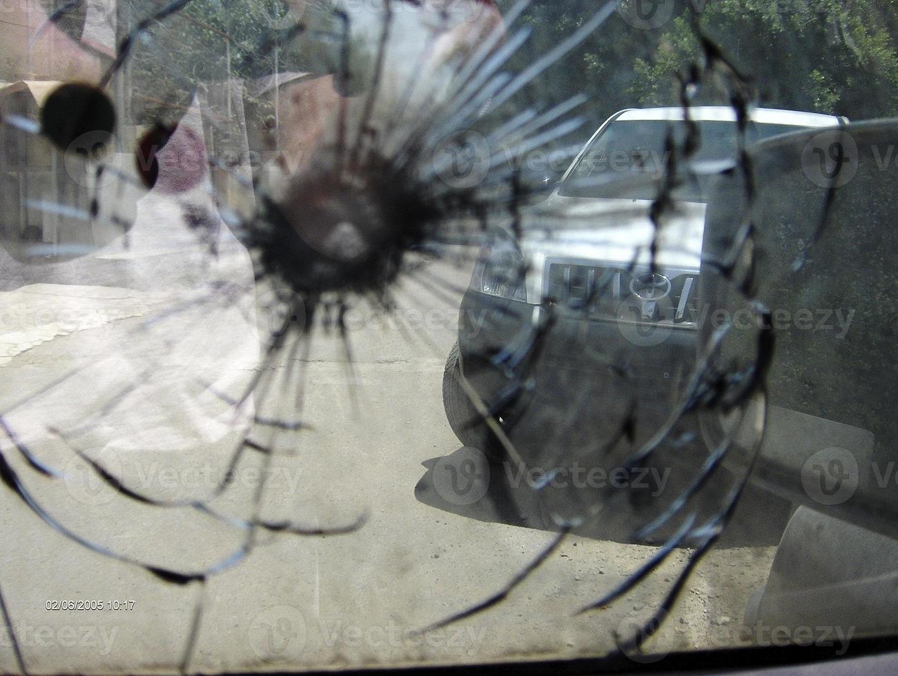 grosse fissure sur le pare-brise de la voiture à partir d'une balle de tireur d'élite militaire fragmentée photo